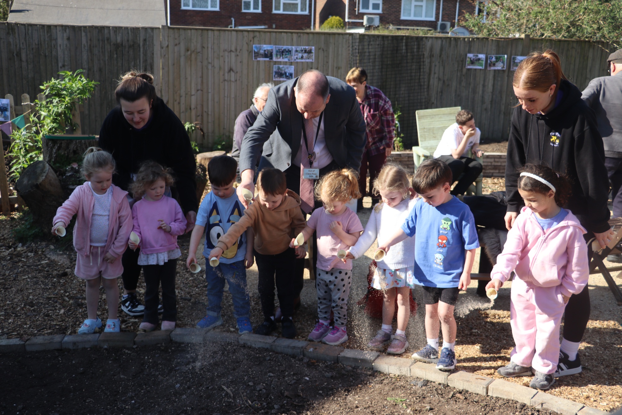 Fledglings children scattering wildflower seed